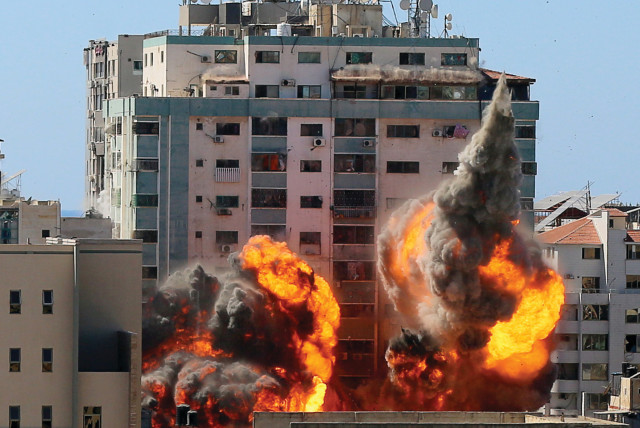 An explosion is seen near al-Jalaa Tower housing AP and Al Jazeera offices during Israeli missile strikes in Gaza City on May 15 (credit: ASHRAF ABU AMRAH / REUTERS)