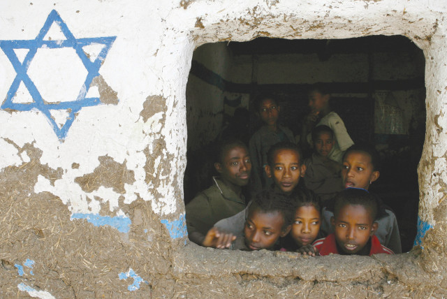 ETHIOPIAN CHILDREN, whose roots trace back to Judaism, look out of a window at a Beta Israel school while awaiting immigration to Israel, in Gondar in 2007.  (credit: ELIANA APONTE/REUTERS)