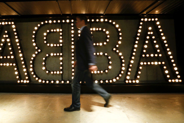  A man walks past the lit logo of the legendary Swedish pop group ABBA at ''ABBA - The Museum'' in Stockholm (credit: ARND WIEGMANN / REUTERS)
