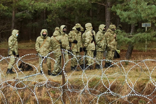 Belarusian soldiers patrol the border as hundreds of migrants try to cross from the Belarus side of the border with Poland near Kuznica Bialostocka, Poland, in this video-grab released by the Polish Defence Ministry, November 8, 2021. (credit: MON/HANDOUT VIA REUTERS)