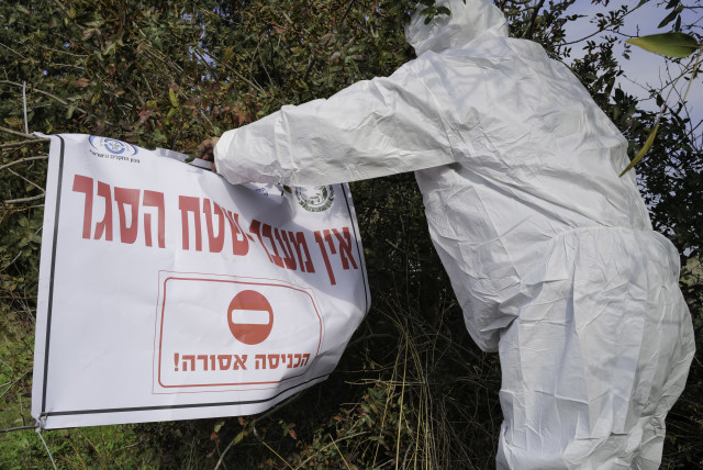  Workers in protective gear seen in Moshav Givat Yoav, in northern Israel, December 29, 2021, following an outbreak of avian influenza (credit: MICHAEL GILADI/FLASH90)