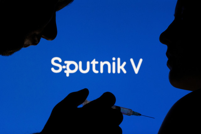 People pose with syringe with needle in front of displayed Sputnik V logo in this illustration taken, December 11, 2021. (credit: REUTERS/DADO RUVIC/ILLUSTRATION)