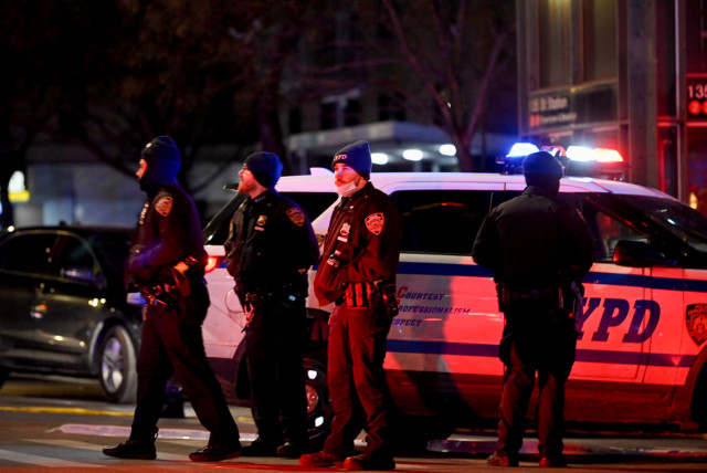 Emergency personnel respond at the scene where NYPD officers were shot while responding to a domestic violence call in the Harlem neighborhood of New York City, US, January 21, 2022. (credit: REUTERS/LLOYD MITCHELL)