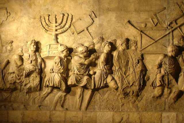  The menorah from the Second Temple is depicted being carried by Romans on the Arch of Titus. (credit: AMOS BEN GERSHOM/GPO)