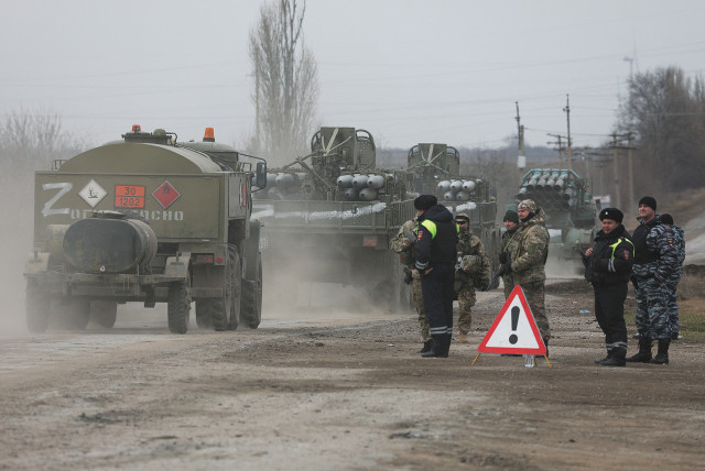  RUSSIAN ARMY military vehicles drive along a street in Armyansk, Crimea, yesterday, after Russian President Vladimir Putin authorized a military operation in eastern Ukraine. (credit: REUTERS)
