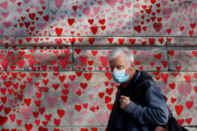  A man wearing a face-mask walks past The National Covid Memorial Wall, on national day of reflection to mark the two year anniversary of the UK going into national lockdown, in London (credit: REUTERS/PETER CZIBORRA)