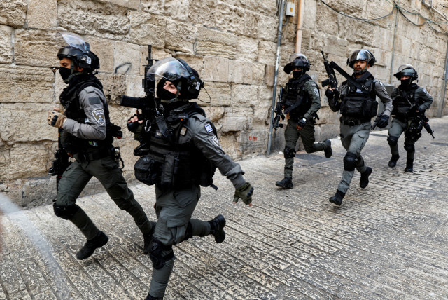  Israeli Border Police officers run in an alley in Jerusalem's Old City April 17, 2022. (credit: AMMAR AWAD/REUTERS)