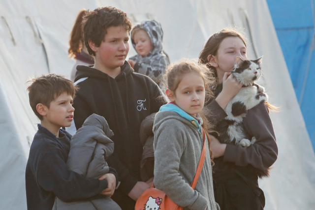  Children are seen with a cat at a temporary accommodation centre for evacuees during Ukraine-Russia conflict in the village of Bezimenne in the Donetsk Region, Ukraine May 1, 2022. (credit: REUTERS/ALEXANDER ERMOCHENKO)