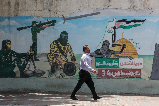  HAMAS ABIDES by its charter: Graffiti depicts Hamas fighters firing rockets, in Khan Younis, May 30. (credit: ABED RAHIM KHATIB/FLASH90)