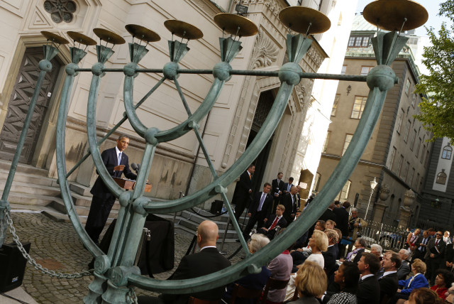  Photographed through a Menorah, former US President Barack Obama participates in a celebration of Raoul Wallenberg at the Great Synagogue and Holocaust Memorial of Stockholm, September 4, 2013 (credit: REUTERS/KEVIN LAMARQUE)