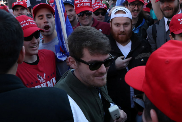 Supporters of the America First ideology and US President Donald Trump cheer on Nick Fuentes, a leader of the America First movement and a white nationalist, as he makes his way through the crowd for a speech during the "Stop the Steal" and "Million MAGA March" protests, November 14, 2020. (photo credit: REUTERS/LEAH MILLIS)