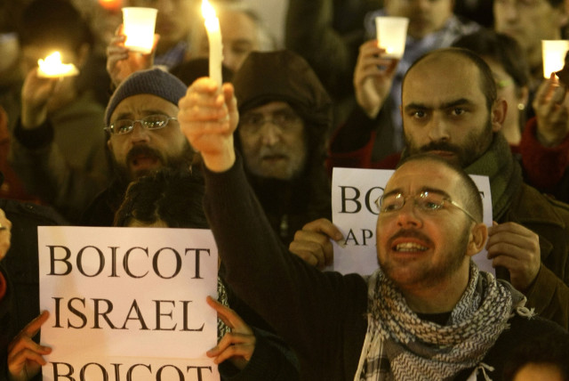 Pro-Palestinian demonstrators hold candles during a protest in front of Catalan Government in Sant Jaume quarter in central Barcelona January 16, 2009 against Israel's attacks on Gaza. The sign reads: ''Boycott Israel, boycott apartheid''. (credit: REUTERS/GUSTAU NACARINO)