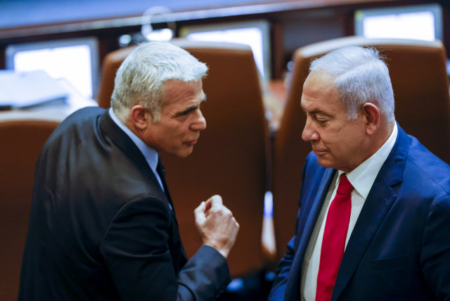 Israeli foreign minister and Head of the Yesh Atid party Yair Lapid walks next to Head of opposition and head of the Likud party Benjamin Netanyahu at the assembly hall for a special session in memory of Israel's first Prime Minister David Ben Gurion, on November 8, 2021.  (credit: OLIVIER FITOUSSI/FLASH90)