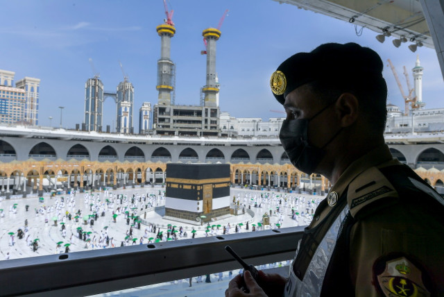  Saudi police officer stands guard as pilgrims arrive to perform their final Tawaf in the Grand Mosque, in the holy city of Mecca, Saudi Arabia, July 20, 2021. (credit: SAUDI MINISTRY OF MEDIA/HANDOUT VIA REUTERS)