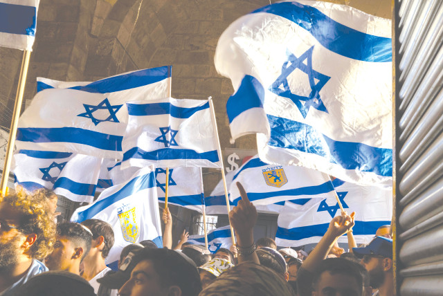  A FLAG march takes place through the Old City on Jerusalem Day, in May. Israel will become a bi-national state and its Jewish expressions, including the national flag, will lose their status and their meaning, the writer warns.  (credit: OLIVIER FITOUSSI/FLASH90)