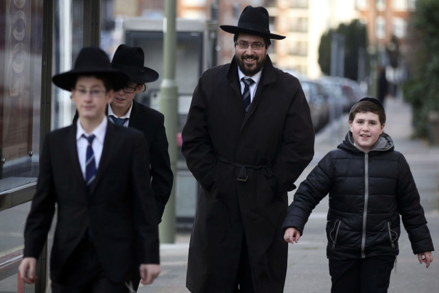  A Jewish man walks with young Jewish boys in Golders Green, London, January 10 , 2015. The Community Security Trust (CST), which provides security advice to Britain's estimated 260,000 Jews, said police in London and Manchester in northern England had agreed to increase patrols at synagogues and ot (credit: REUTERS/PAUL HACKETT)
