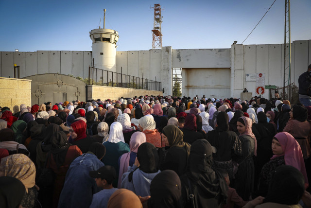  Israeli security forces guard as Palestinians make their way through an Israeli checkpoint to attend Friday prayer of the holy fasting month of Ramadan in Jerusalem's Al-Aqsa mosque, near the West Bank city of Bethlehem, April 29, 2022. (credit: WISAM HASHLAMOUN/FLASH90)