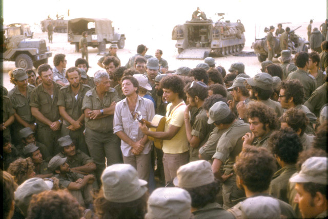  LEONARD COHEN entertaining weary IDF troops during the Yom Kippur War, accompanied on guitar by Israeli singer-songwriter Matti Caspi, with Gen. Ariel Sharon in close attendance. (credit: Doron Yaakovi)