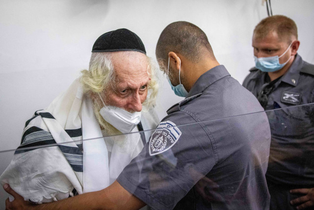  Rabbi Eliezer Berland covered with a prayer shawl arrives for a court hearing arrives for a police investigation at a police station in Jerusalem, November 2, 2021.  (credit: YONATAN SINDEL/FLASH90)