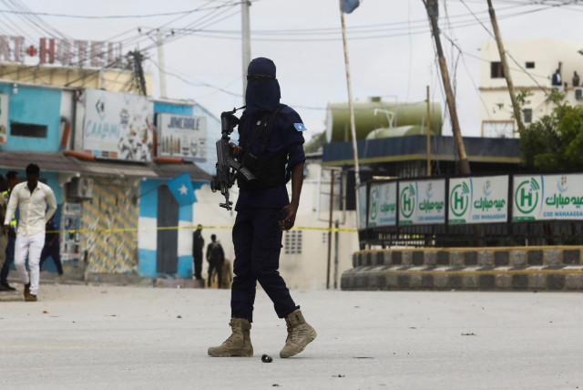 A Somali security officer walks at the entrance of Hotel Hayat, the scene of an al Qaeda-linked al Shabaab group militant attack in Mogadishu, Somalia August 20, 2022 (photo credit: REUTERS/FEISAL OMAR)