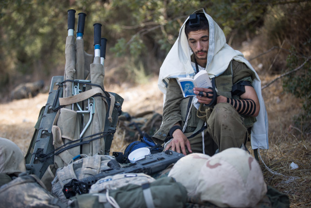  THE ZIONIST identity didn’t overcome the Jewish identity, nor did the opposite occur: An IDF soldier puts on tefillin. (credit: YONATAN SINDEL/FLASH90)