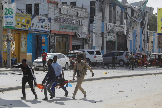  An injured civilian is evacuated from the scene of an explosion near the education ministry building along K5 street in Mogadishu (credit: REUTERS)