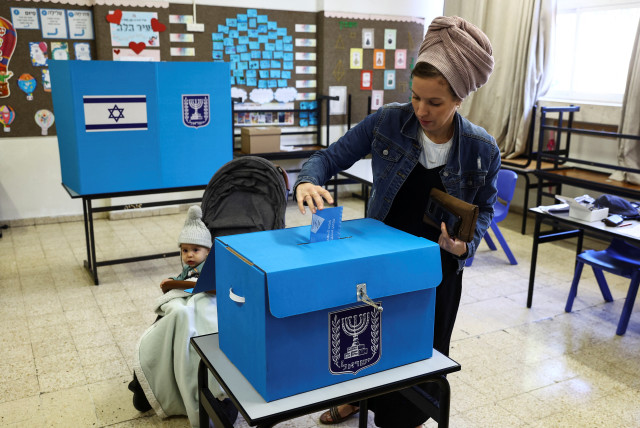  An Israeli woman casts her ballot on the day of Israel's general election in a polling station in Kiryat Arba, a Jewish settlement in the West Bank November 1, 2022. (credit: REUTERS/Ronen Zvulun)