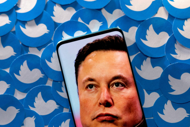  An image of Elon Musk is seen on a smartphone placed on printed Twitter logos in this picture illustration taken April 28, 2022.  (photo credit: REUTERS/DADO RUVIC/ILLUSTRATION/FILE PHOTO)