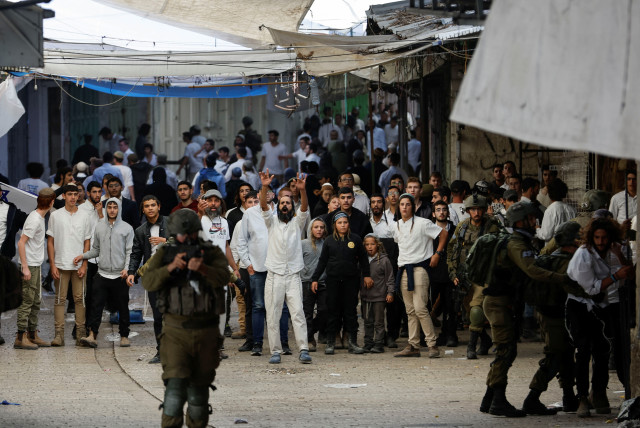  Israeli settlers gather during a scuffle with Palestinians in the West Bank city of Hebron, November 19, 2022. (photo credit: REUTERS/MUSSA QAWASMA)
