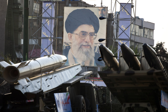 Iranian-made Fateh 110 (Conqueror) (L) and Persian Gulf (R) missiles are seen next to a portrait of Iran's Supreme Leader Ayatollah Ali Khamenei at a war exhibition  (credit: Morteza Nikoubazl/Reuters)