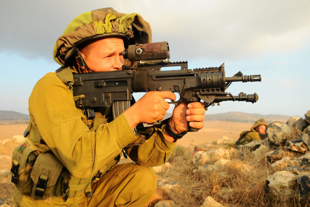 A soldier from the Granite Battalion of the Nahal Brigade is seen holding a Tavor rifle while training in the Golan Heights (Illustrative). (credit: Nir Gal, IDF Spokesperson's Unit/Flickr)