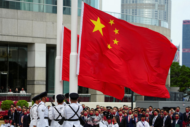  Police officers raise Chinese and Hong Kong flags during a ceremony to mark the Chinese National Day in Hong Kong, China October 1, 2022. (credit: REUTERS/LAM YIK)