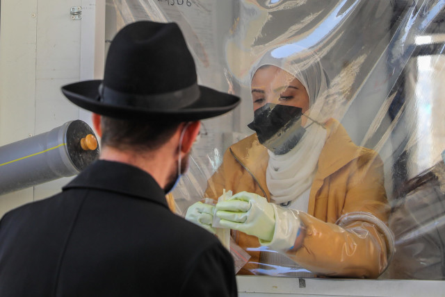  A coronavirus test in Jerusalem. COVID goes beyond conflict and affects everyone. January 2022. (credit: MARC ISRAEL SELLEM/THE JERUSALEM POST)