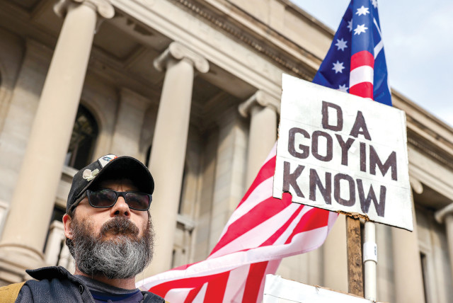  A protester carries an antisemitic sign outside the Kenosha County Courthouse on the second day of jury deliberations in the Kyle Rittenhouse trial, in Kenosha, Wisconsin, on November 17, 2021.  (credit: EVELYN HOCKSTEIN/REUTERS)