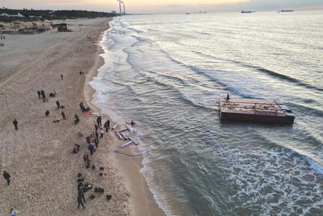  AN AERIAL view shows people gathering near a shipping container that was washed up on the shore in Ashkelon, on Wednesday. (credit: AMIR COHEN/REUTERS)