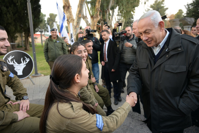  Israeli Prime Minister Benjamin Netanyahu is seen shaking a female IDF soldier's hand while visiting IDF's Northern Command, on January 10, 2023. (credit: AMOS BEN GERSHOM/GPO)