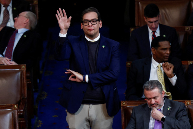  Newly elected Rep. George Santos (R-NY), who is facing a scandal over his resume and claims he made on the campaign trail, makes a gesture with his left hand as he casts his vote for House Republican Leader Kevin McCarthy from the House Chamber during a 10th round of voting for the new Speaker. (photo credit: REUTERS/Evelyn Hockstein/File Photo)