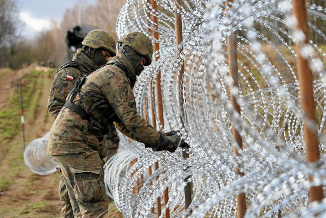  Soldiers build razor wire fence on Poland's border with Russia's exclave of Kaliningrad near Bolcie, Poland November 3, 2022.  (credit: ARKADIUSZ STANKIEWICZ/AGENCJA WYBORCZA.PL VIA REUTERS)
