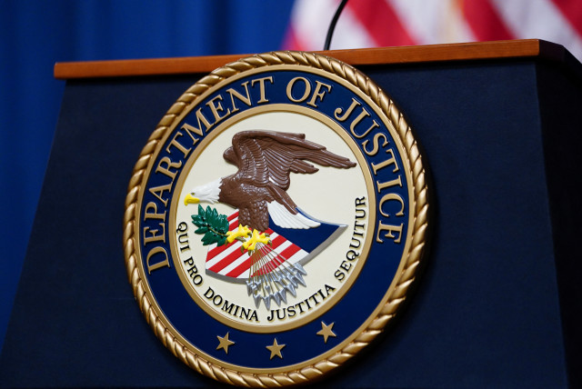  The seal of the US Justice Department is seen on the podium in the Department's headquarters briefing room before a news conference with the Attorney General in Washington, January 24, 2023. (credit: REUTERS/KEVIN LAMARQUE)