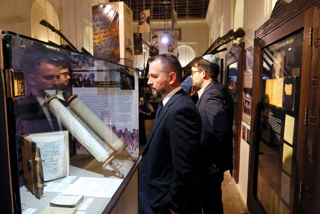  Visitors attend an event commemorating International Holocaust Remembrance Day in which a 16th-century Torah scroll that survived the Holocaust was officially unveiled at Crossroad of Civilizations Museum, in Dubai, on January 28.  (photo credit: AbdelHadi Ramahi/Reuters)