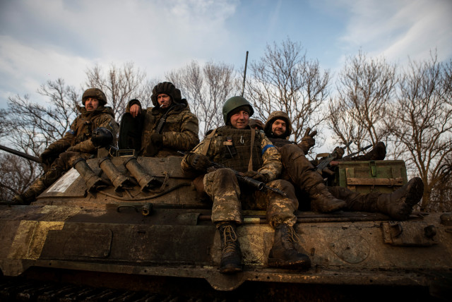  Ukrainian servicemen sit atop a BMP-2 infantry fighting vehicle on a road outside the frontline town of Bakhmut, amid Russia's attack on Ukraine, in Donetsk region, Ukraine February 11, 2023 (credit: REUTERS/Yevhenii Zavhorodnii)