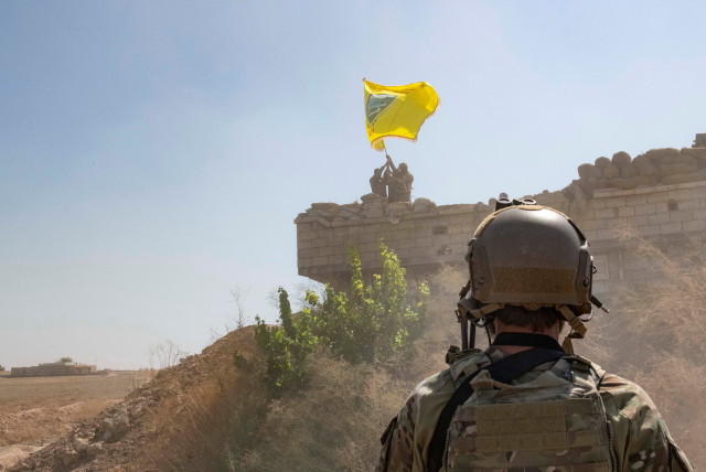 Ένας αμερικανός στρατιώτης επιβλέπει μέλη των Συριακών Δημοκρατικών Δυνάμεων καθώς κατεδαφίζουν μια οχύρωση YPG και υψώνουν μια σημαία του Στρατιωτικού Συμβουλίου του Tal Abyad πάνω από το φυλάκιο ως μέρος της συμφωνίας για τη ζώνη του μηχανισμού ασφαλείας, στη Συρία, 21 Σεπτεμβρίου 2019. (πίστωση: US ARMY/STAFF SGT ANDREW GOEDL/HANDOUT ΜΕΣΩ REUTERS)