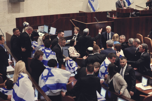   OPPOSITION MKS wrap themselves in Israeli flags during the Knesset vote on judicial reform on Monday night. (credit: MARC ISRAEL SELLEM/THE JERUSALEM POST)