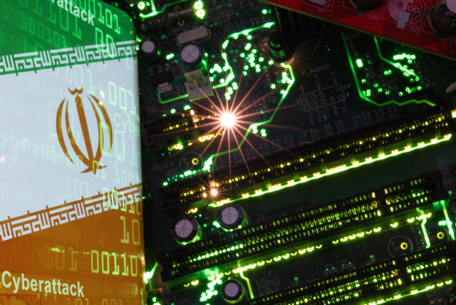  A smartphone with a displayed Iranian flag with the word ''Cyberattack'' and binary codes over it is placed on a computer motherboard in this illustration taken February 23, 2023. (credit: DADO RUVIC/REUTERS)