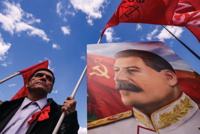  A SUPPORTER of the Russian Communist Party stands next to a portrait of Soviet leader Joseph Stalin, during a May Day rally in Moscow last year. (credit: MAXIM SHEMETOV/REUTERS)