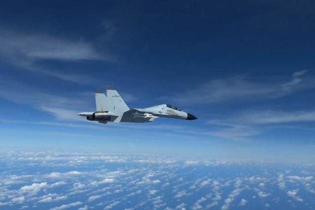  A Chinese Navy J-11 fighter jet is recorded flying close to a US Air Force RC-135 aircraft in international airspace over the South China Sea, according to the US military, in a still image from video taken December 21, 2022. (credit: US Indo-Pacific Command/Handout via REUTERS)