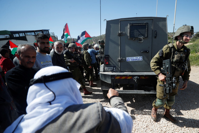  Israeli forces stand guard near their vehicle as Palestinians protest against a new Israeli settlement near Ramallah in the Israeli West Bank, March 10, 2023. (credit: MOHAMAD TOROKMAN/REUTERS)