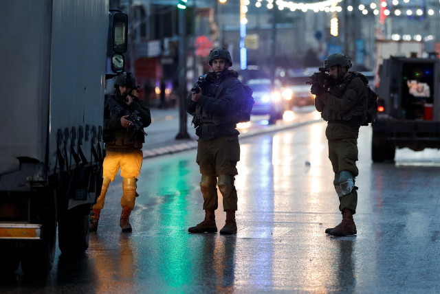  Israeli troops stand guard at a shooting scene, in Huwara, in the West Bank, March 19, 2023. (credit: MOHAMAD TOROKMAN/REUTERS)