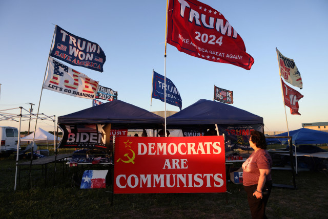  A supporter of former U.S. president Donald Trump walks pass merchant booths ahead of the Trump's first campaign rally after announcing his candidacy for president in the 2024 election at an event, in Waco, Texas, US, March 24, 2023. (credit: REUTERS/JIM URQUHART)