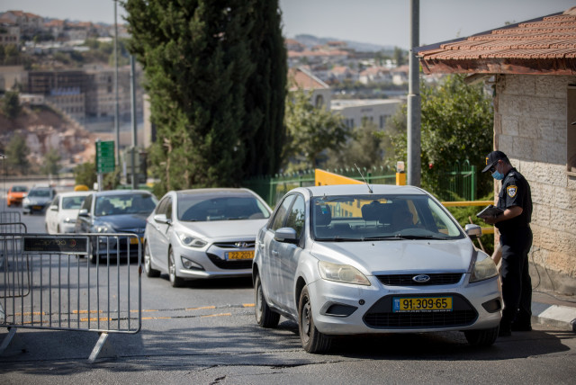 Police guard at a temporary roadblock in the Jewish settlement of Beitar Illit, during the Jewish holiday of Sukkot, October 7, 2020. (credit: NATI SHOHAT/FLASH90)